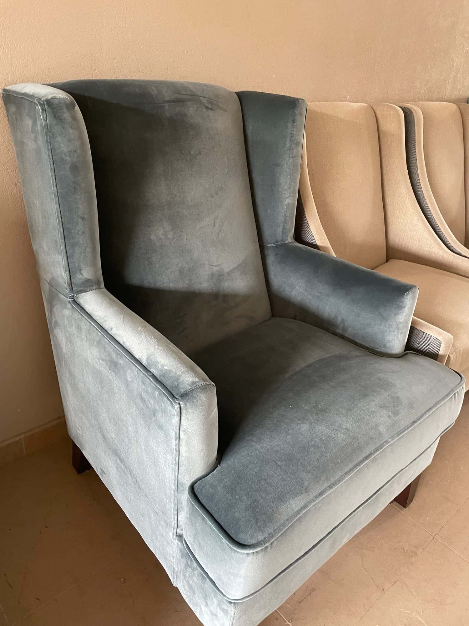 Sillón orejero tapizado en terciopelo gris