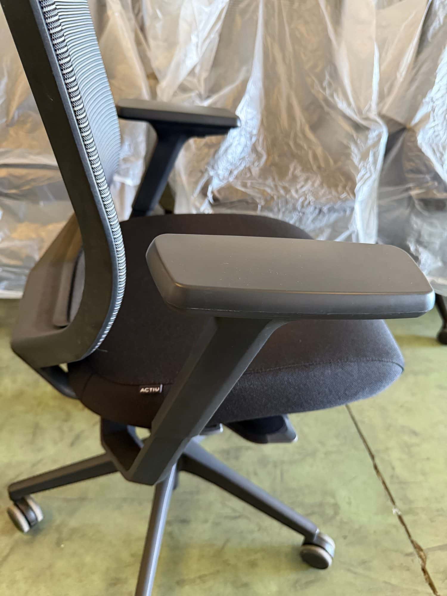 Detalle del brazo y el asiento de una silla de oficina ergonómica