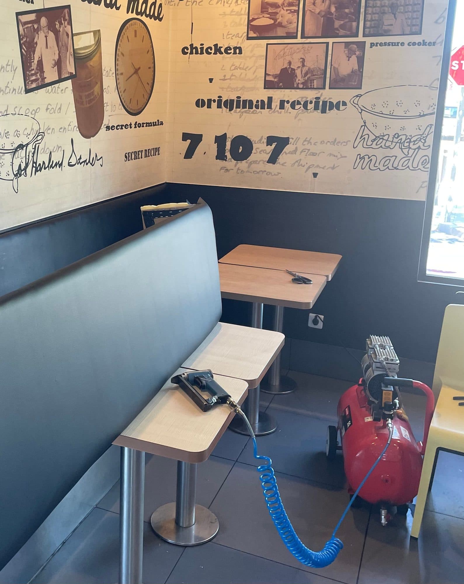 Trabajo de tapicería en los bancos de un restaurante con compresor y grapadora