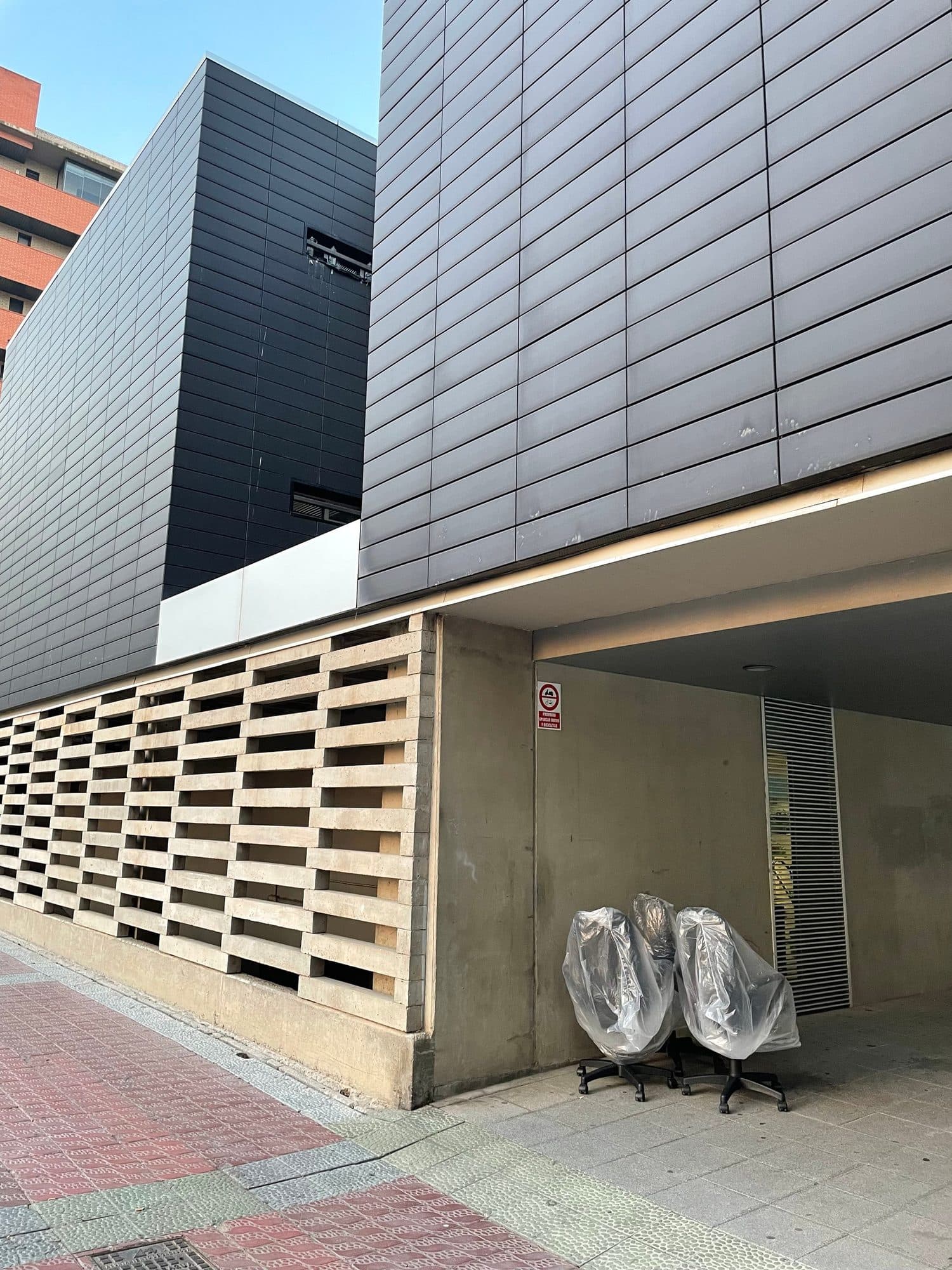 Sillas de oficina protegidas a la entrada de un edificio de oficinas