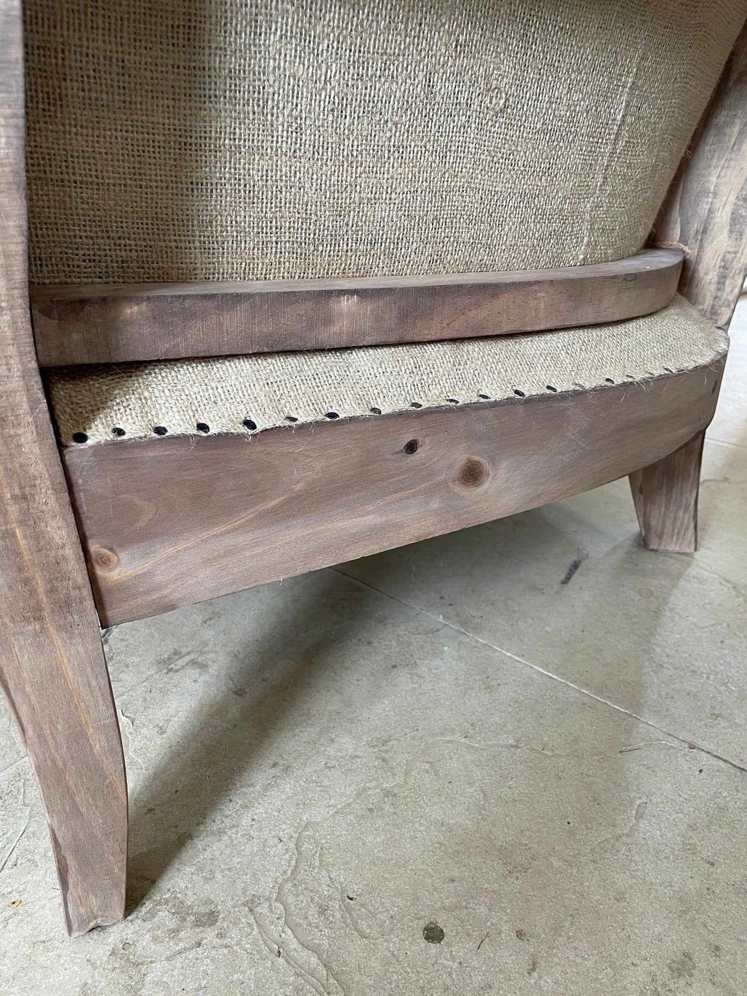 Arpillera clavada sobre el armazón de madera de un asiento durante el guarnecido tradicional