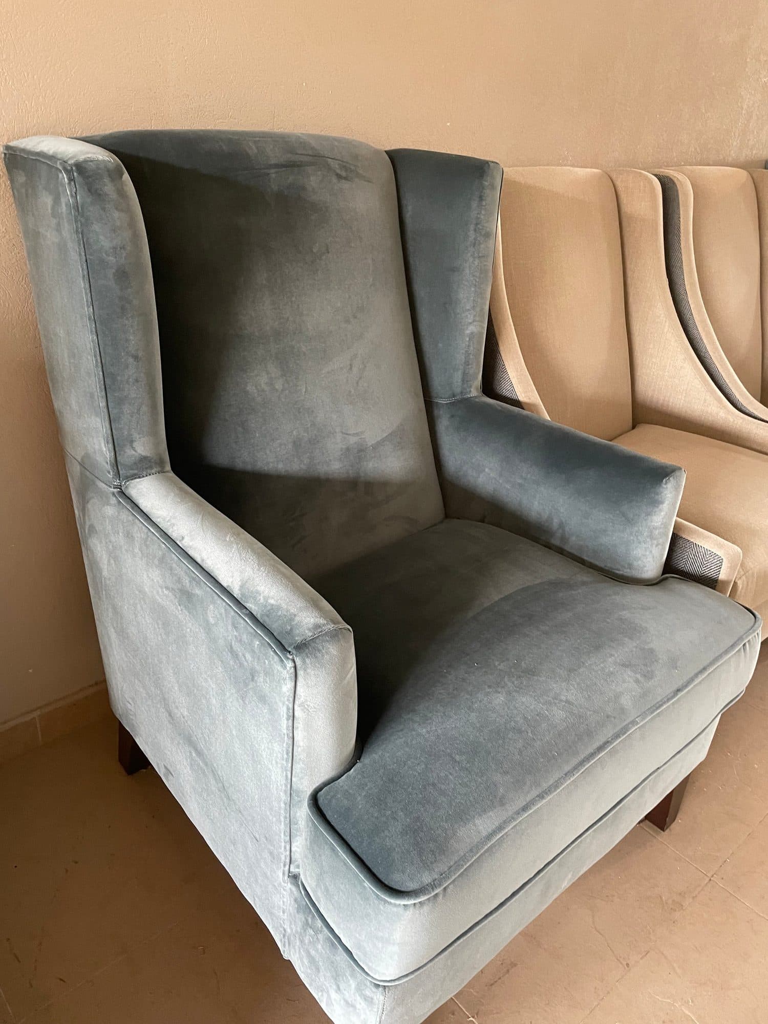 Sillón orejero tapizado en terciopelo gris