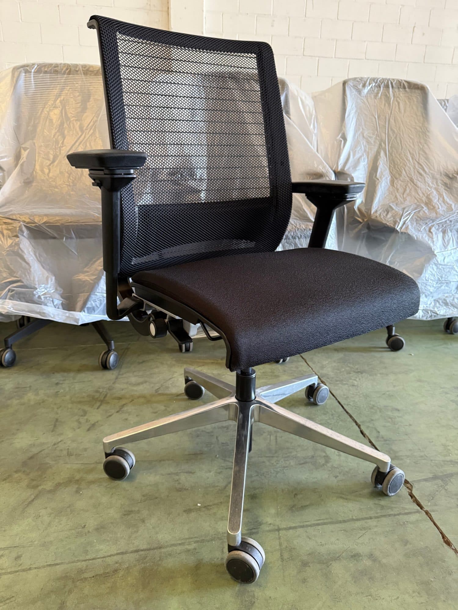 Silla de oficina ergonómica con respaldo de malla revisada en el taller