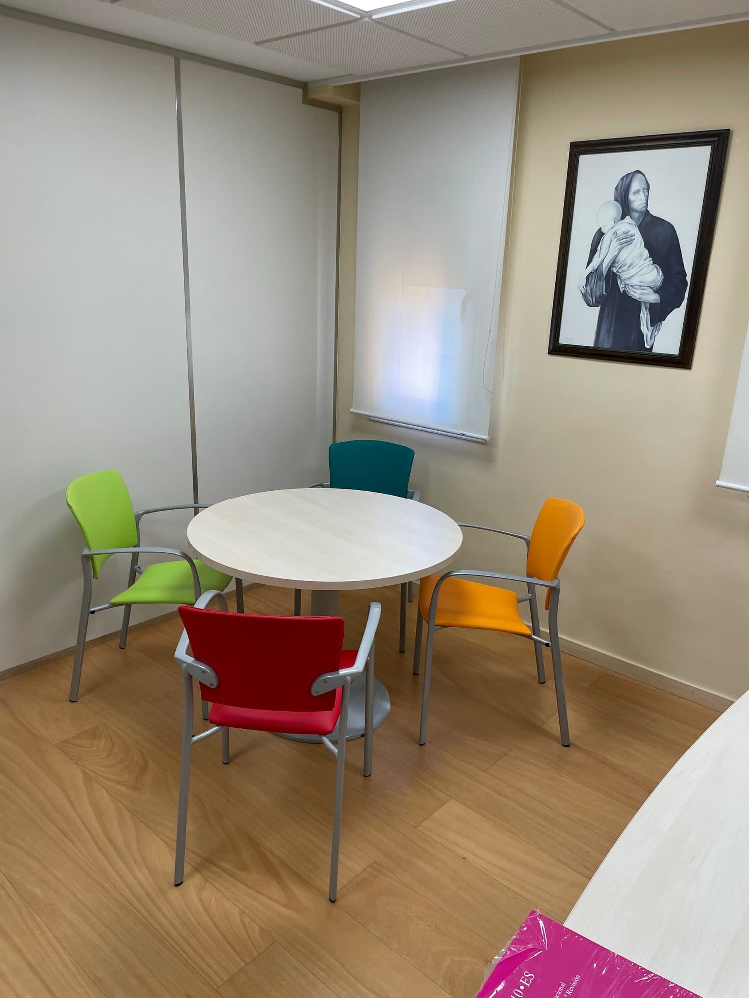 Sala de reuniones con sillas de confidente tapizadas en verde, turquesa, rojo y naranja