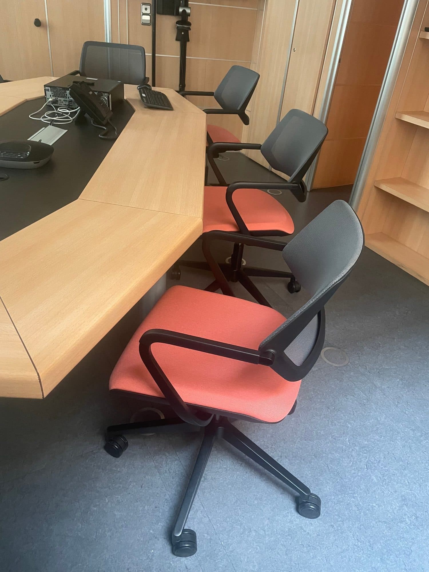 Sala de juntas con sillas de oficina de respaldo de malla y asiento coral retapizado