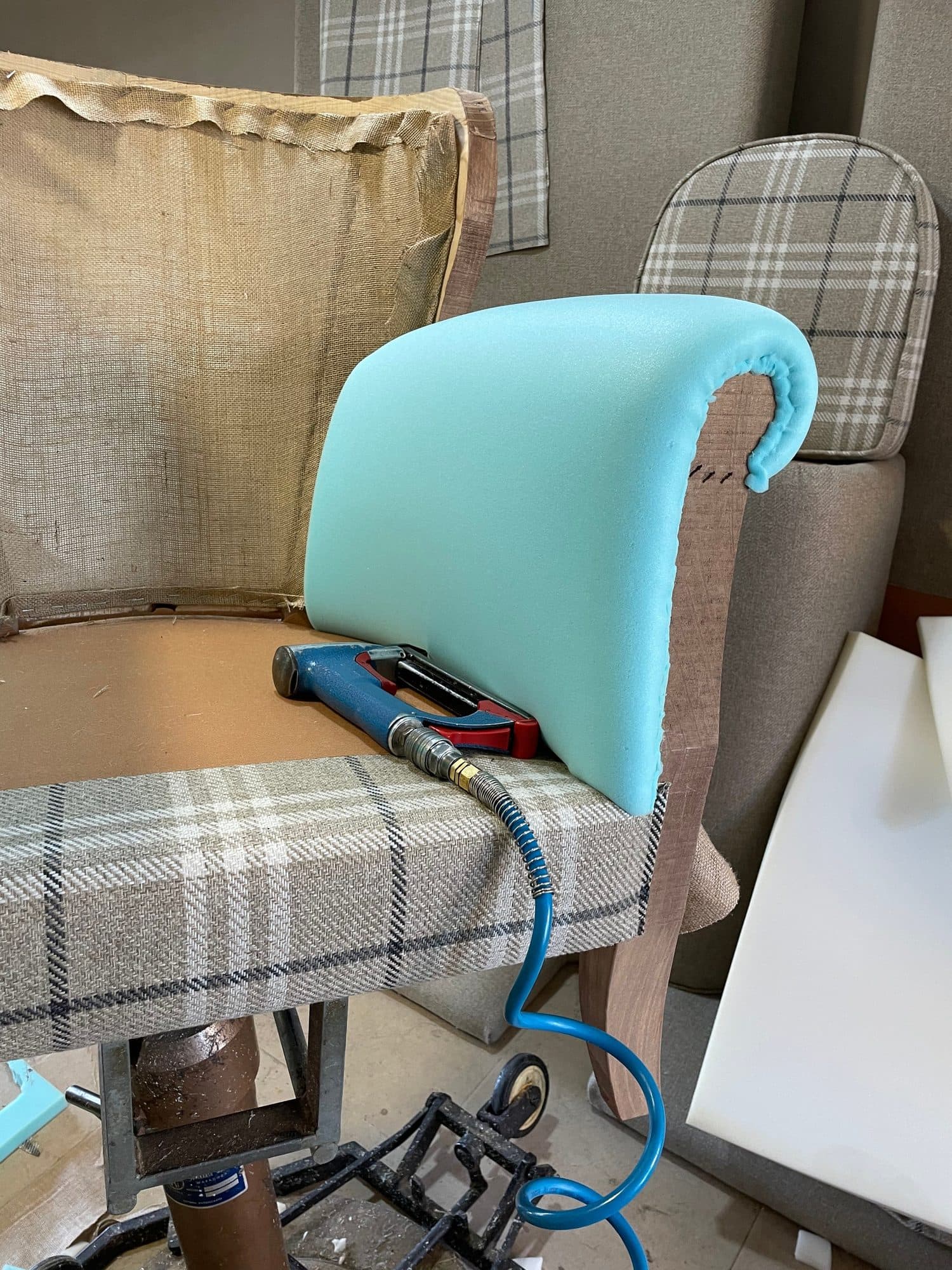 Sillón en proceso de tapizado con el brazo acolchado antes de colocar el tejido