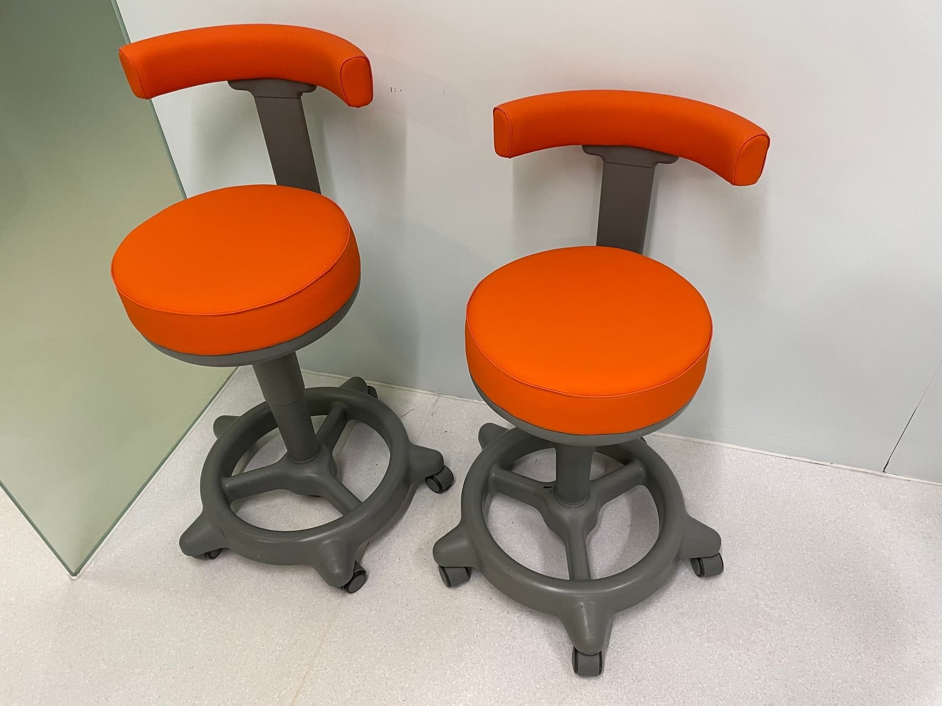 Dos taburetes de clínica dental retapizados en naranja