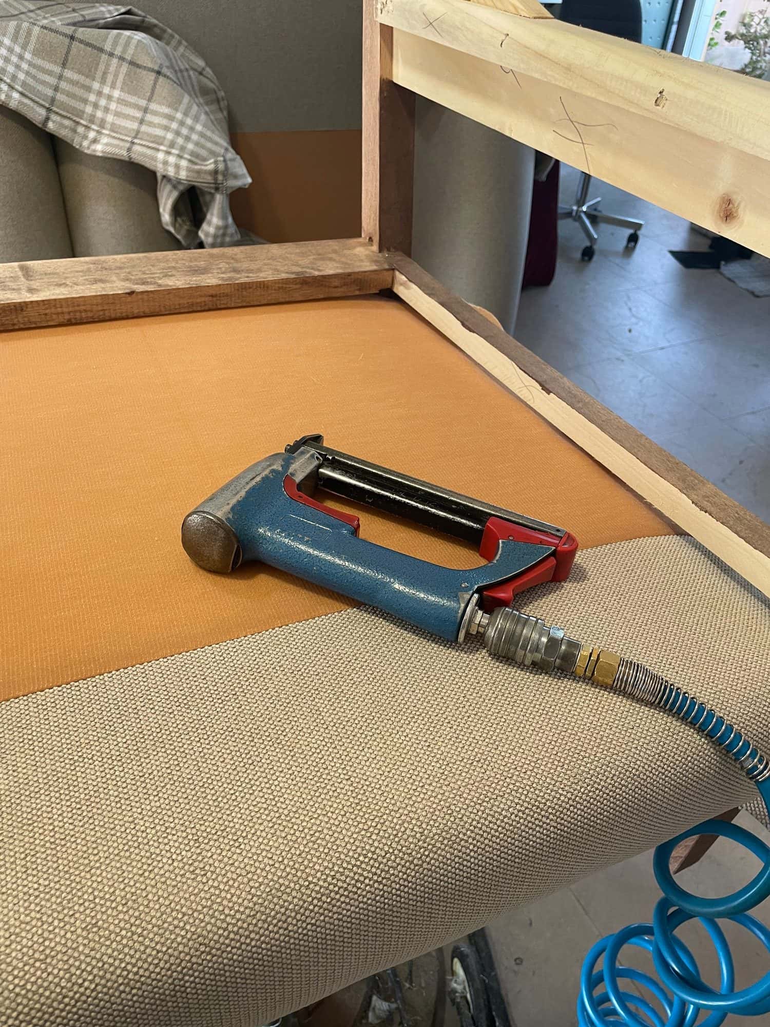 Grapadora neumática de tapicero sobre un asiento en fabricación